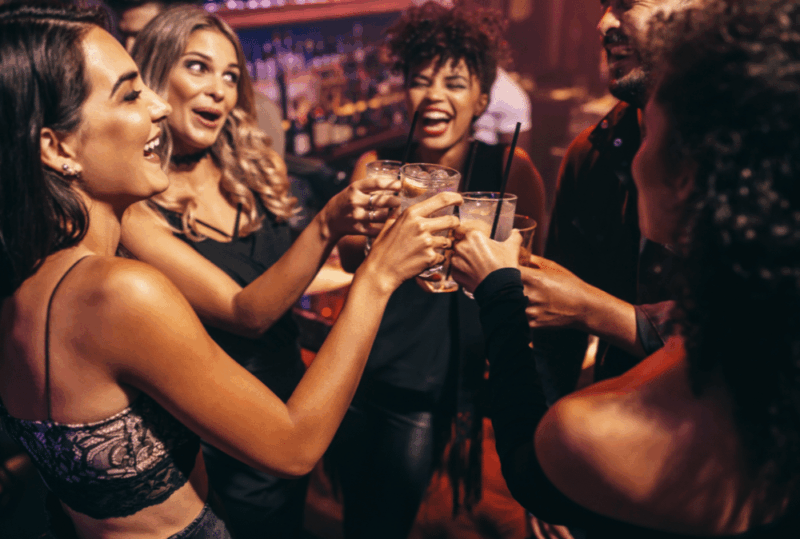 Image is of a group of young adults toasting each other at a party, concept of disciplinary action due to a UF student arrest