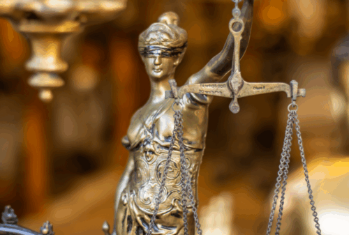 Image is of a close-up of a bronze statuette of Lady Justice, concept of knowing your rights after being arrested in Gainesville
