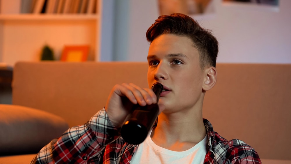Teen drinking alcohol showing risks of underage drinking laws in Florida