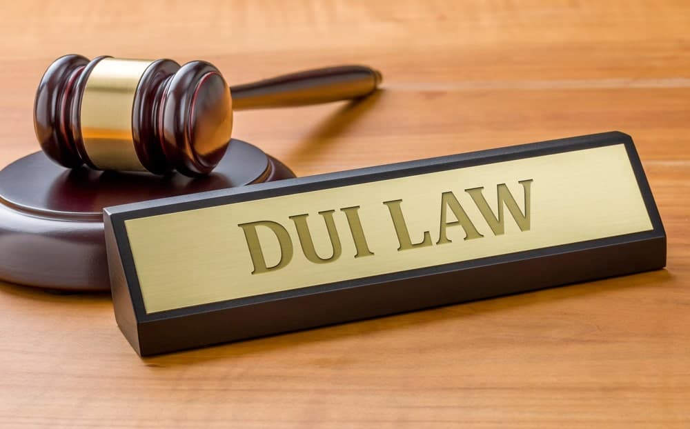 Image is of a courtroom gavel beside a plaque reading DUI Law, concept of legal consequences of a first time DUI in Florida.