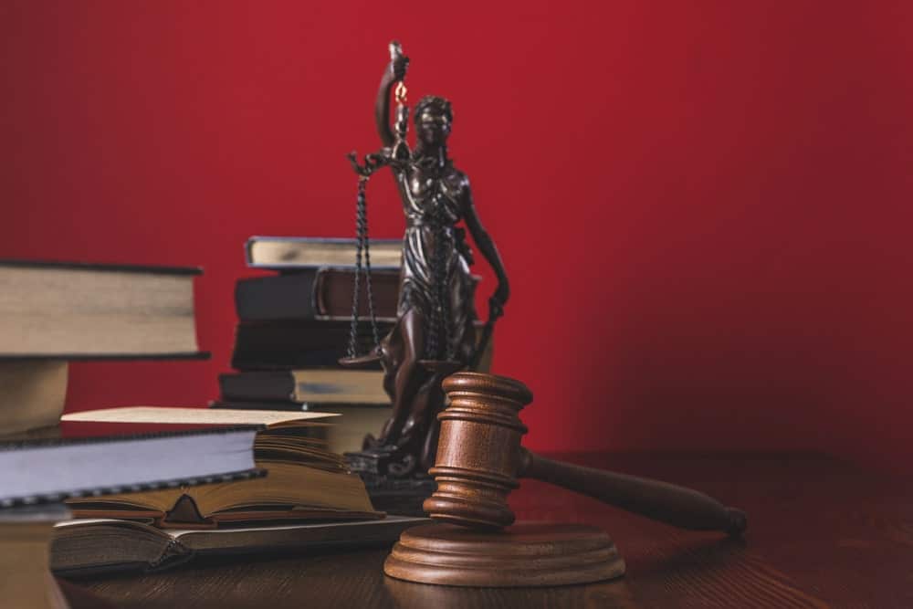 Image shows law books, a wooden gavel, and a Lady Justice statue on a desk, representing legal guidance after a DUI arrest in Gainesville.