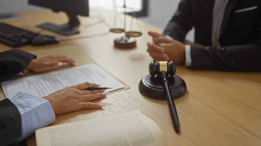 Image is of two legal professionals discussing documents at a desk, symbolizing attorney guidance during expungement in Florida cases.