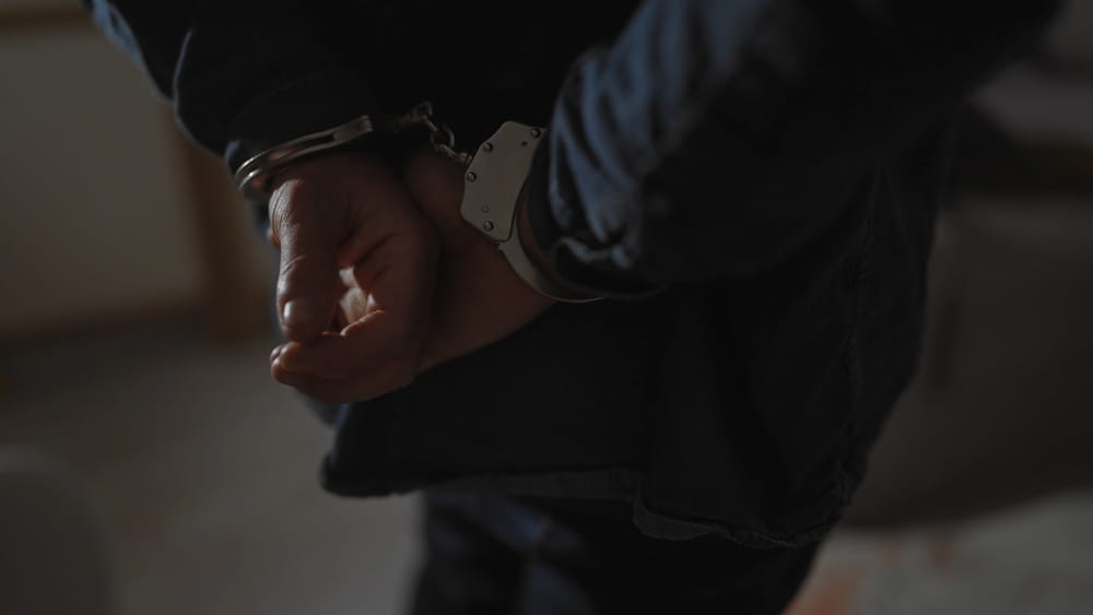 Image is of hands in handcuffs behind a person’s back, concept of expungement in Florida and seeking relief from an arrest record.