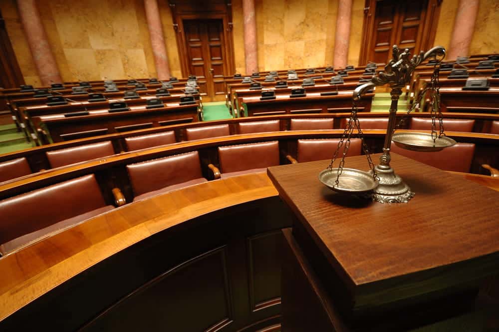 Image is of a courtroom interior with scales of justice, symbolizing judicial oversight in court-ordered expungement cases