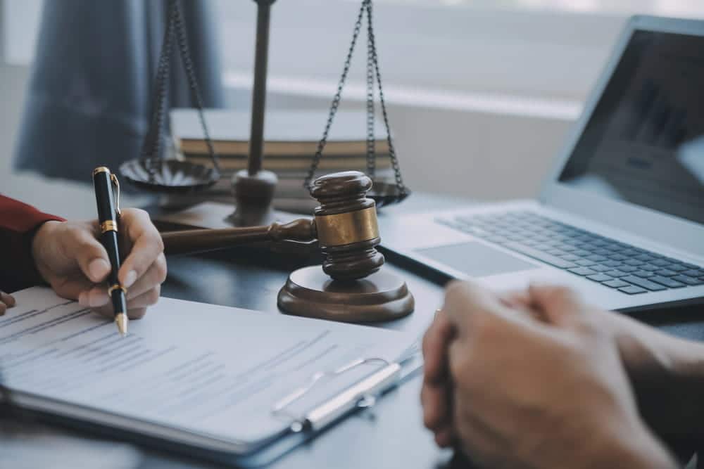 Image is of a lawyer reviewing documents with a client at a desk, concept of expungement options after a dismissed case