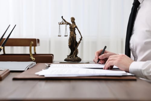 Expungement lawyer in Florida reviewing court petition with Lady Justice statue representing legal justice