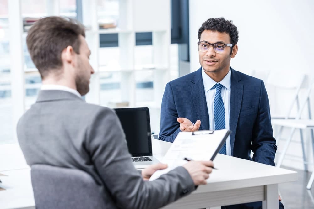 Image is of a lawyer discussing paperwork with a client during a consultation, concept of dismissed charges and expungement process