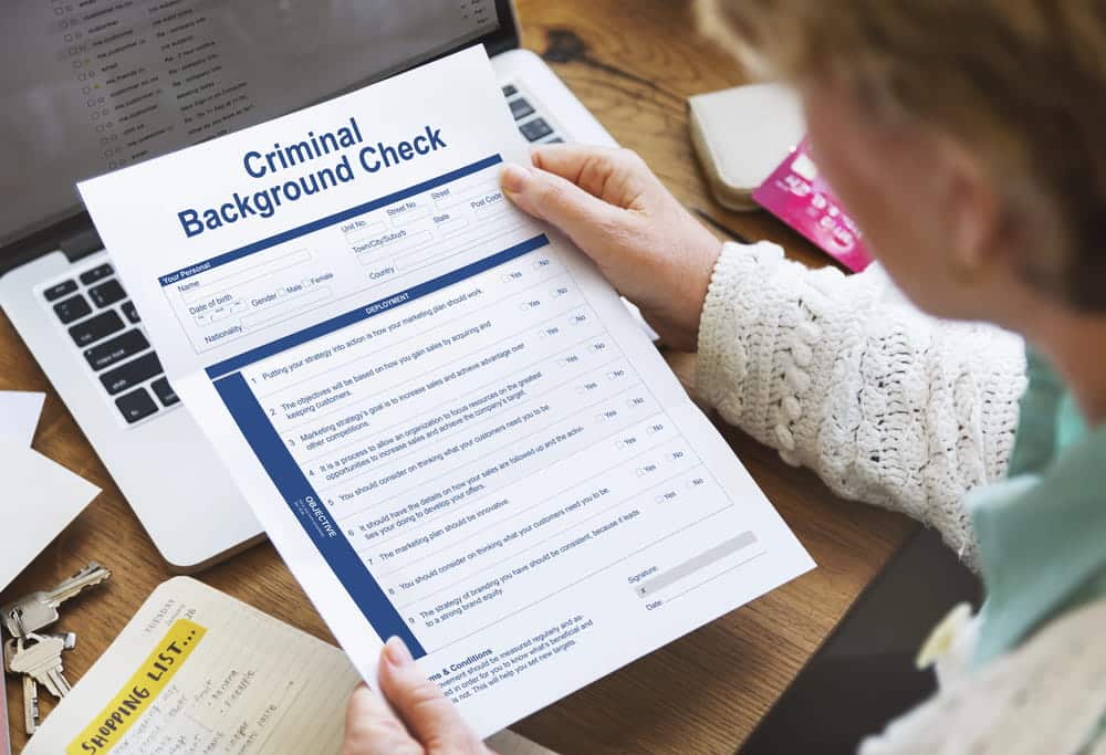 Image is of a person reviewing a criminal background check document on a desk, concept of administrative expungements in FL