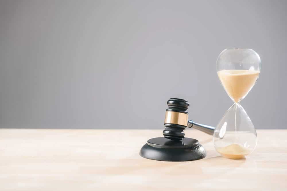 Image is of a judge’s gavel beside an hourglass, symbolizing time and decisions in a court-ordered expungement