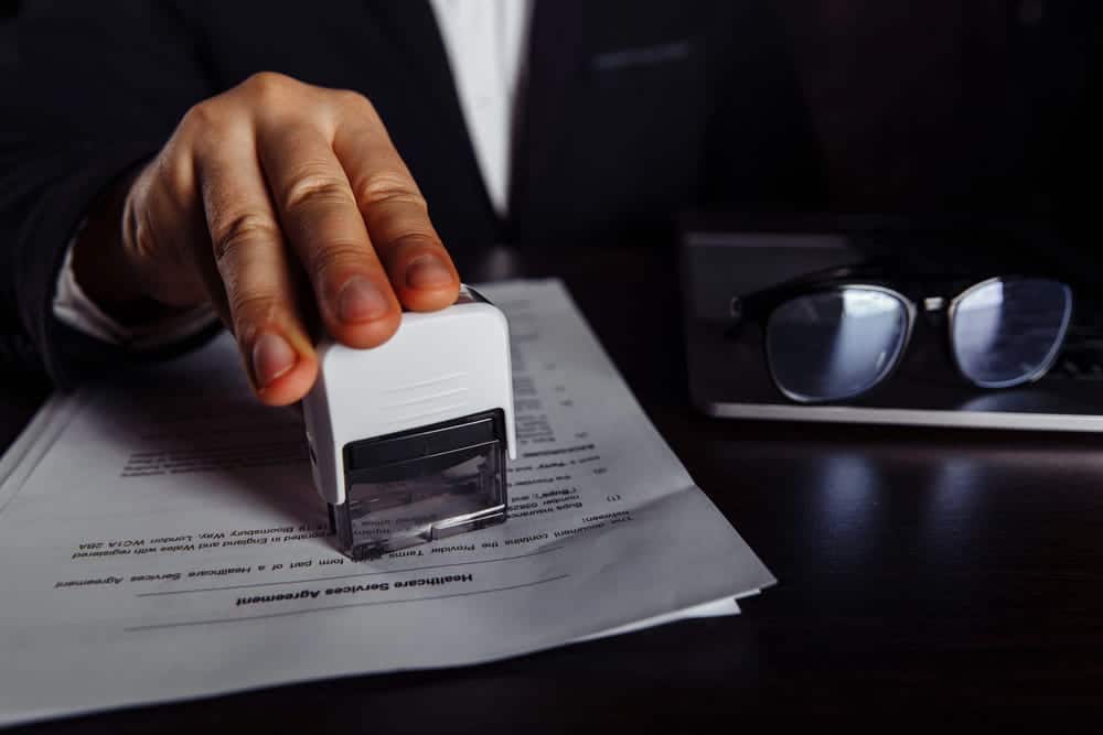 Image is of individuals analyzing a criminal record form on a computer, concept of administrative expungement and background record correction